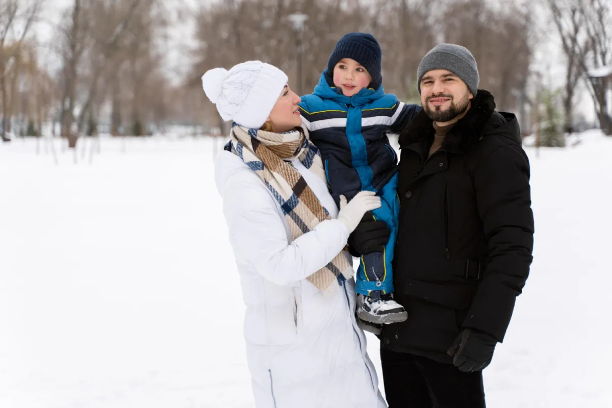 Smiling family bundled up in snow