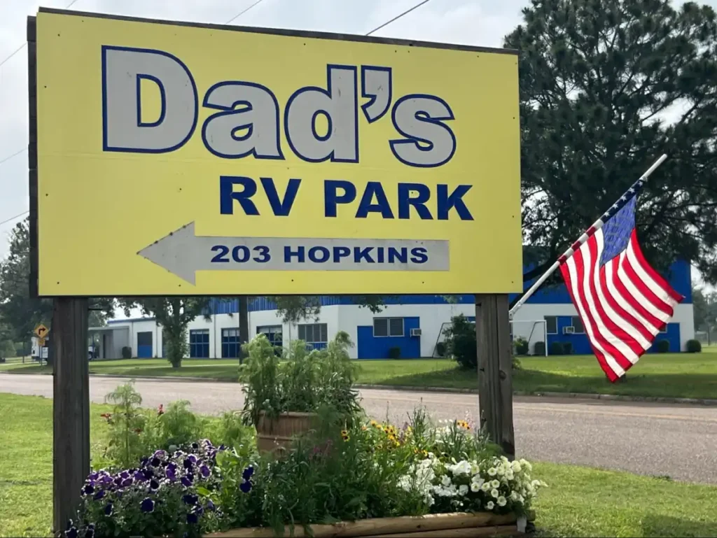 Dad’s RV Park roadside sign with flowers