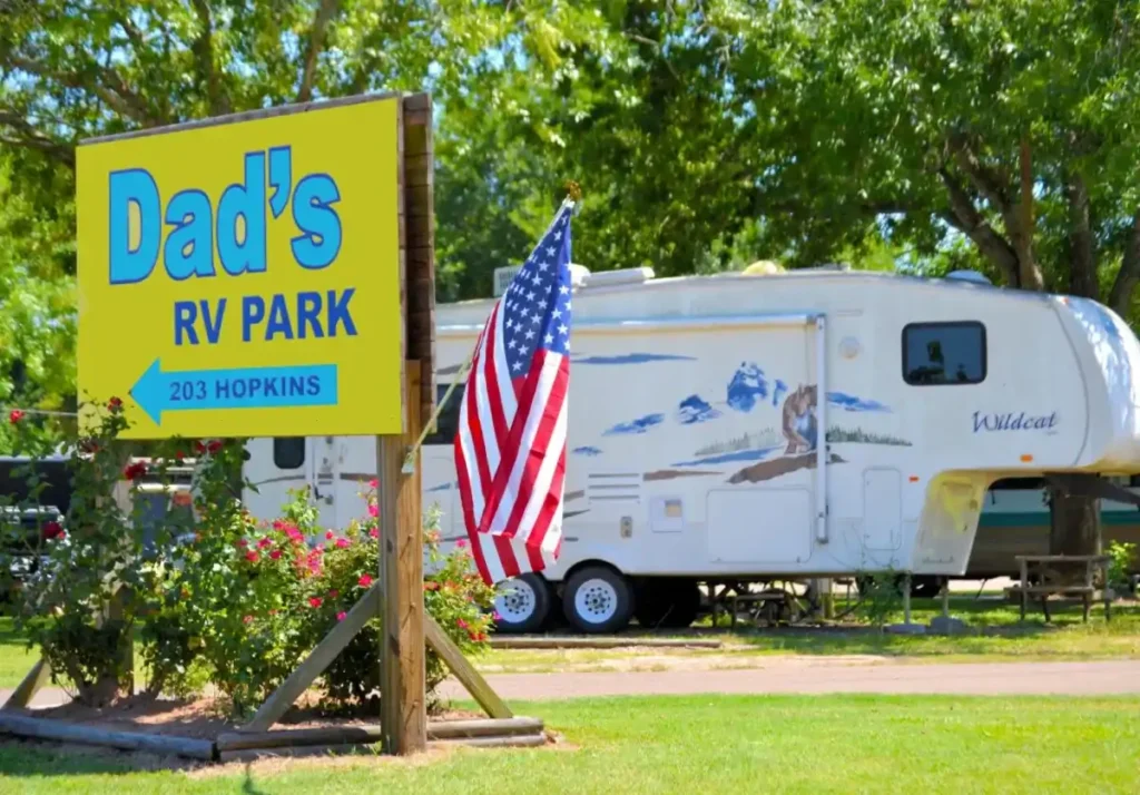 Dad's RV Park entrance sign with parked camper